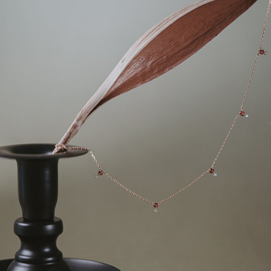 Dainty gold garnet station necklace with sparkling moissanite star accents