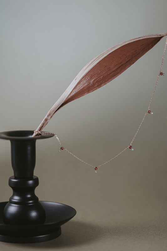 Dainty gold garnet station necklace with sparkling moissanite star accents