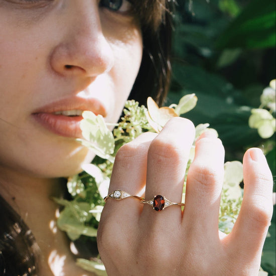 LIRAE vintage-style gold ring featuring an oval red garnet center stone and geometric rhombus accents with milgrain detailing, Art Deco stacking jewelry.