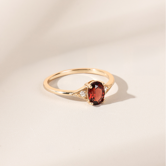 LIRAE vintage-style gold ring featuring an oval red garnet center stone and geometric rhombus accents with milgrain detailing, Art Deco stacking jewelry.