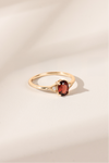LIRAE vintage-style gold ring featuring an oval red garnet center stone and geometric rhombus accents with milgrain detailing, Art Deco stacking jewelry.