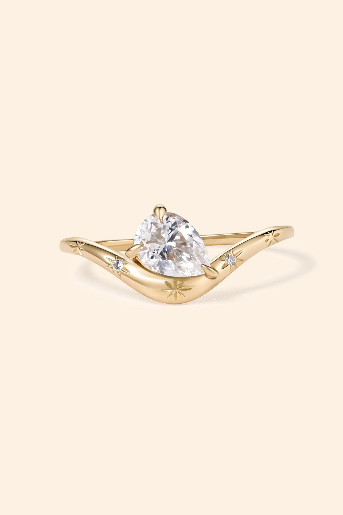 Gold vermeil pear cut diamond ring with engraved star details.