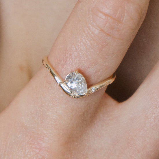 Gold vermeil pear cut diamond ring with engraved star details.