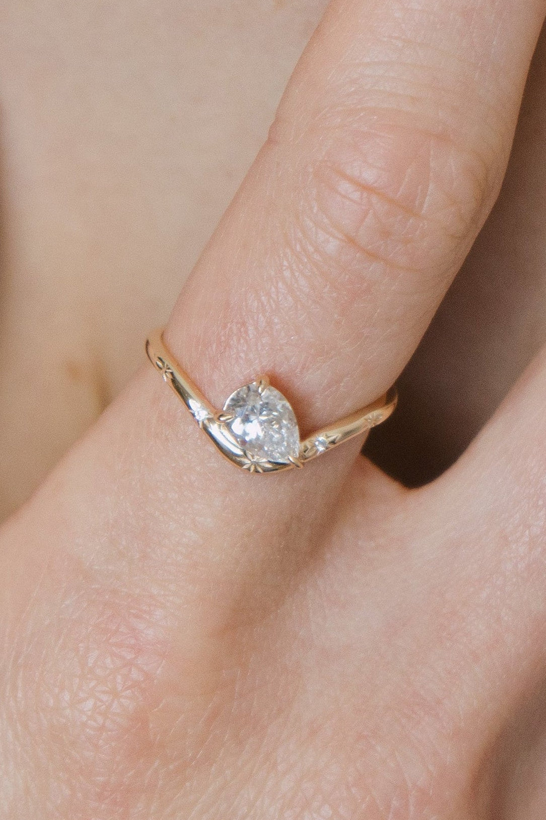 Gold vermeil pear cut diamond ring with engraved star details.