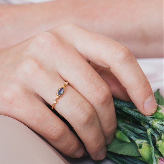 Dainty gold iolite eye ring with marquise purple-blue center stone and sparkling side stones