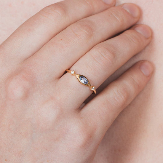 Dainty gold iolite eye ring with marquise purple-blue center stone and sparkling side stones
