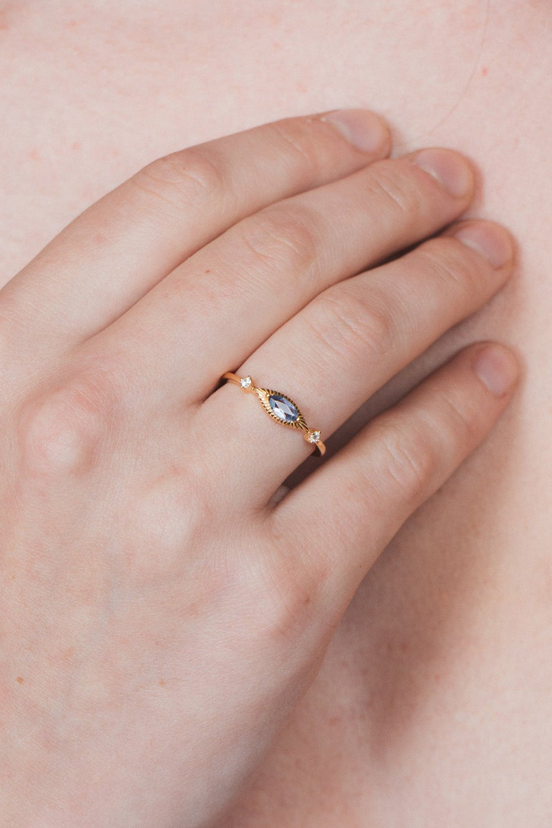 Dainty gold iolite eye ring with marquise purple-blue center stone and sparkling side stones