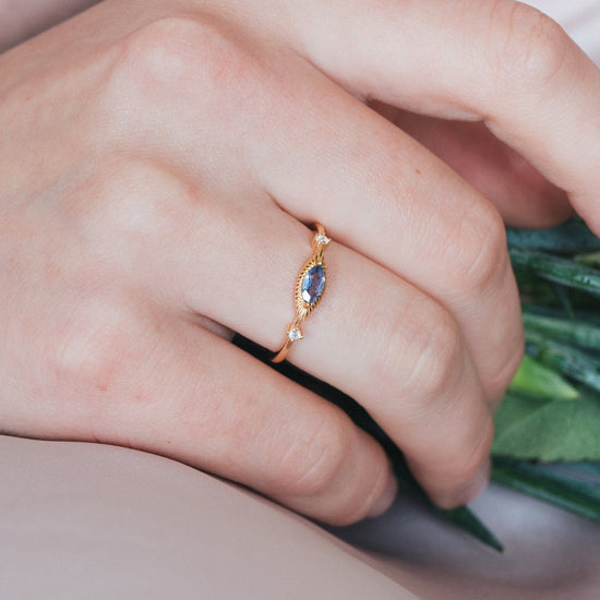 Dainty gold iolite eye ring with marquise purple-blue center stone and sparkling side stones