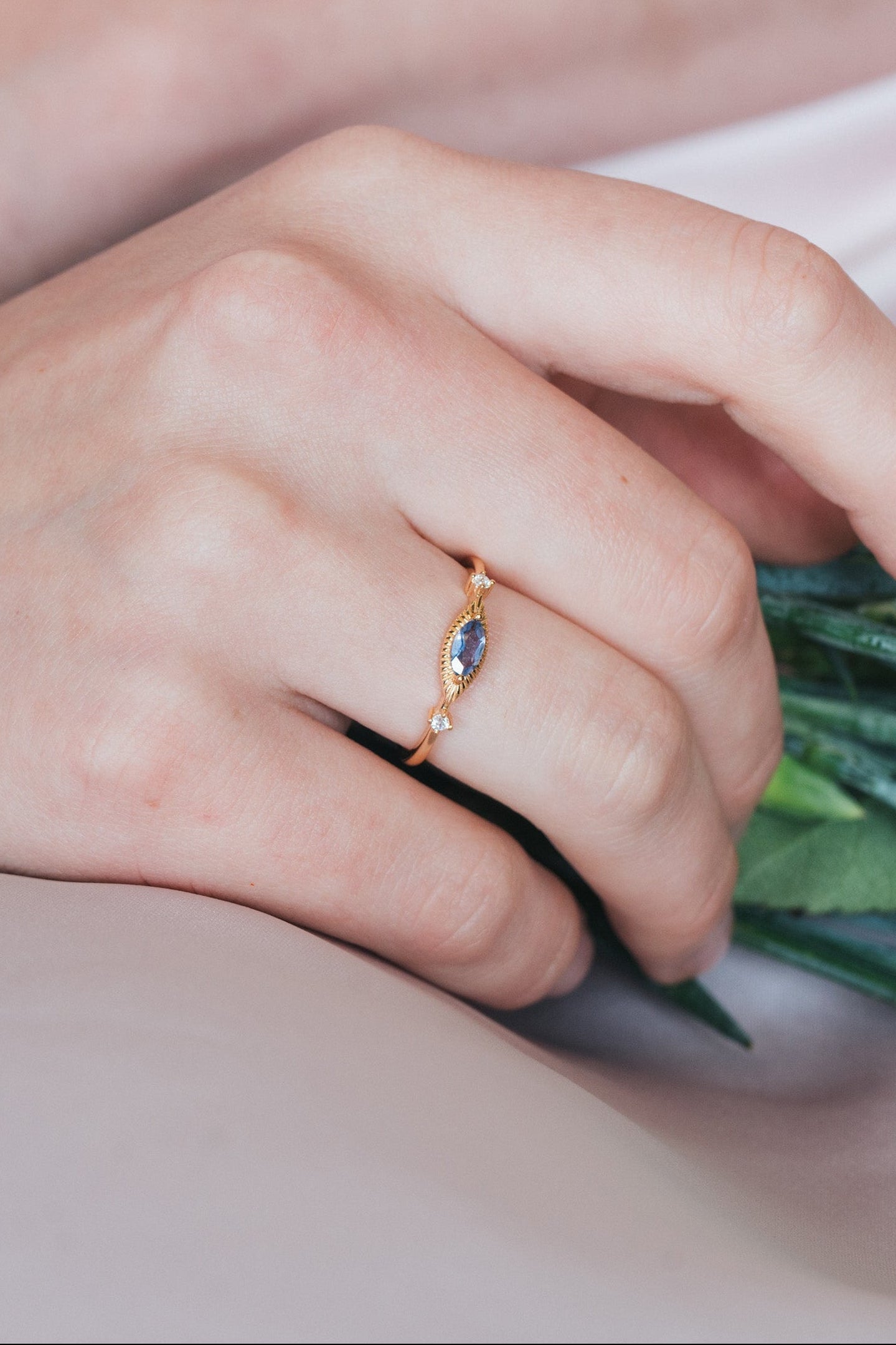 Dainty gold iolite eye ring with marquise purple-blue center stone and sparkling side stones