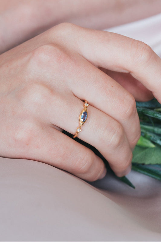 Dainty gold iolite eye ring with marquise purple-blue center stone and sparkling side stones