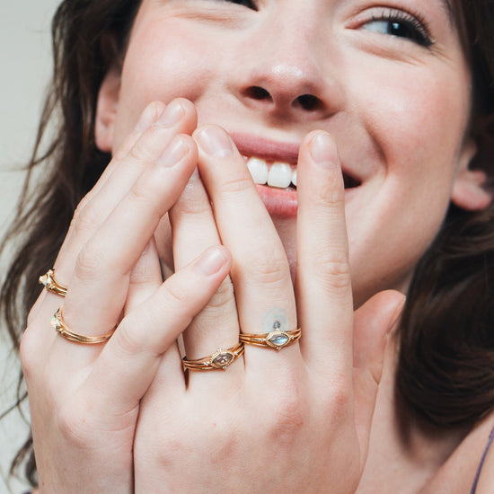 Marquise-cut flashy labradorite ring in 14k gold with a triple-band design and gold north star accent, ethereal celestial jewelry by LIRAE.