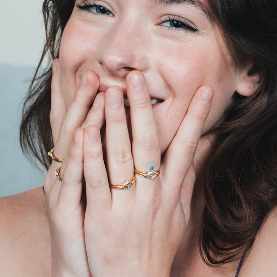 Marquise-cut flashy labradorite ring in 14k gold with a triple-band design and gold north star accent, ethereal celestial jewelry by LIRAE.