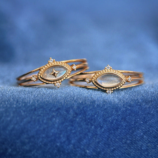 Marquise-cut flashy labradorite ring in 14k gold with a triple-band design and gold north star accent, ethereal celestial jewelry by LIRAE.