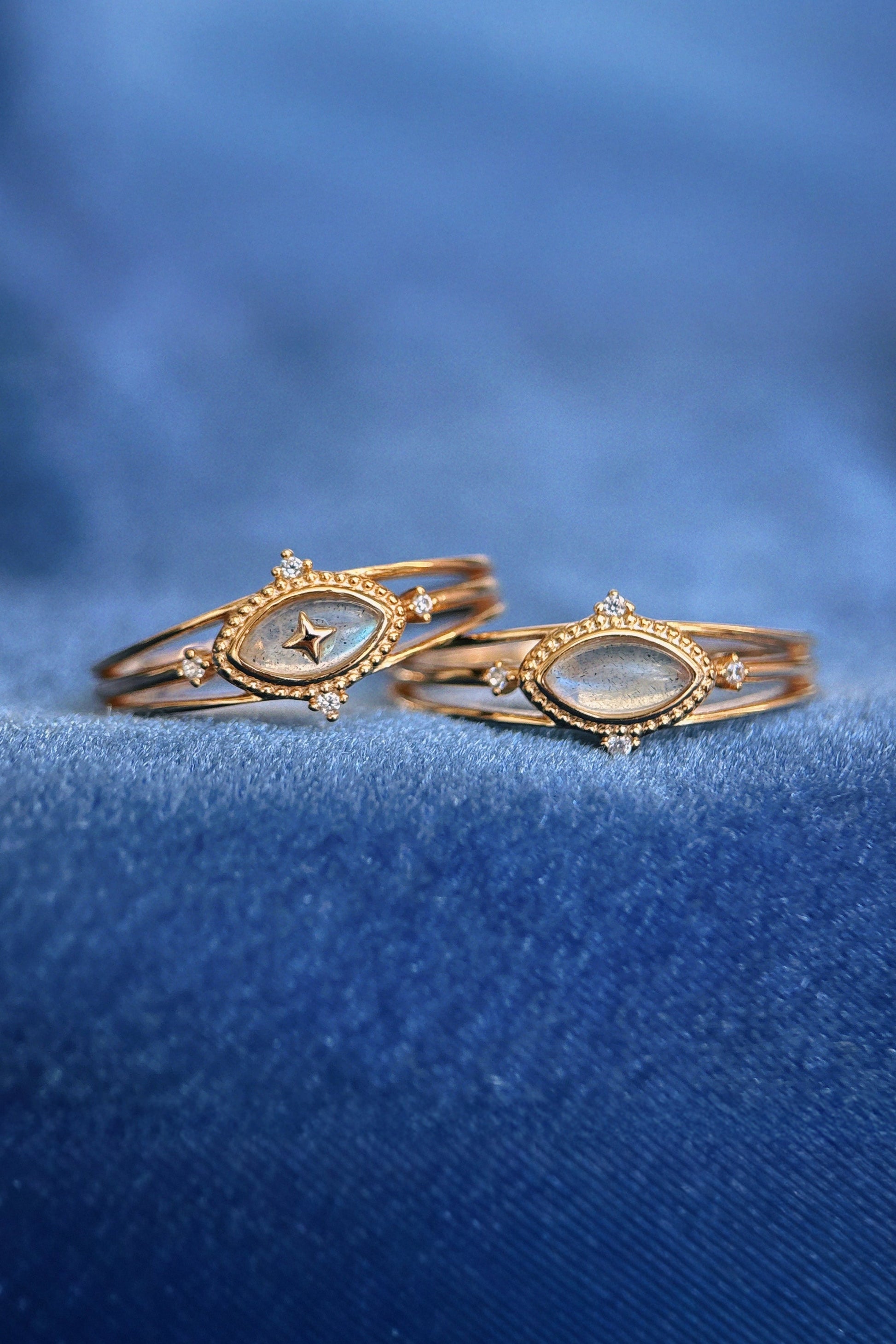 Marquise-cut flashy labradorite ring in 14k gold with a triple-band design and gold north star accent, ethereal celestial jewelry by LIRAE.