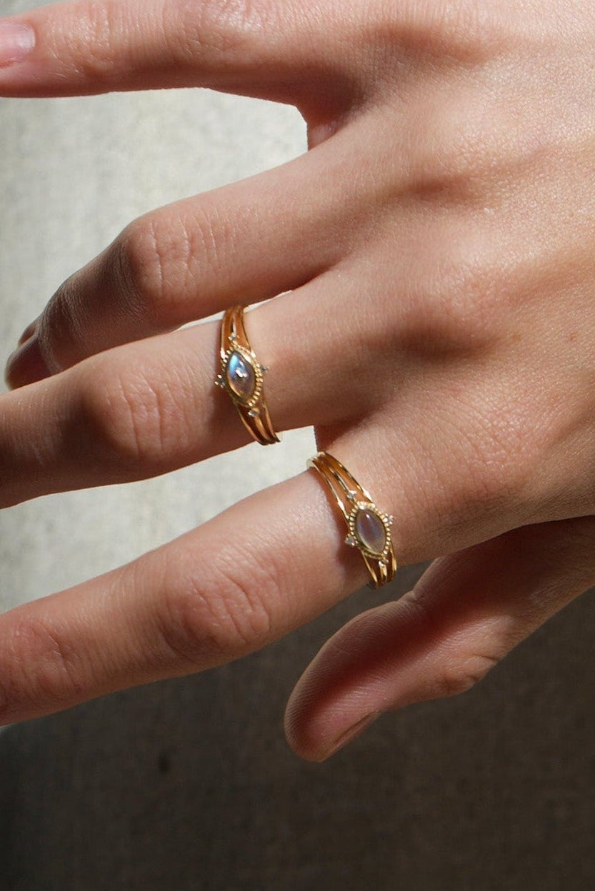 Marquise-cut flashy labradorite ring in 14k gold with a triple-band design and gold north star accent, ethereal celestial jewelry by LIRAE.