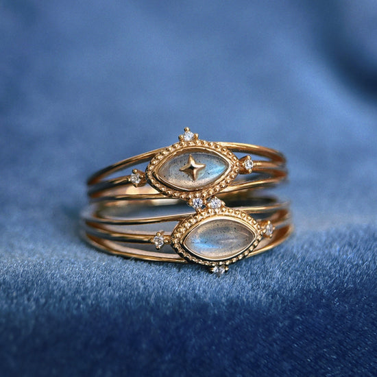 Marquise-cut flashy labradorite ring in 14k gold with a triple-band design and gold north star accent, ethereal celestial jewelry by LIRAE.