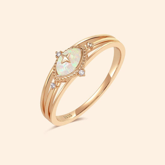 Marquise-cut iridescent opal ring in gold with a triple-band design and north star accents, ethereal celestial jewelry by LIRAE.