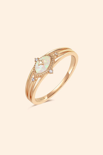 Marquise-cut iridescent opal ring in gold with a triple-band design and north star accents, ethereal celestial jewelry by LIRAE.