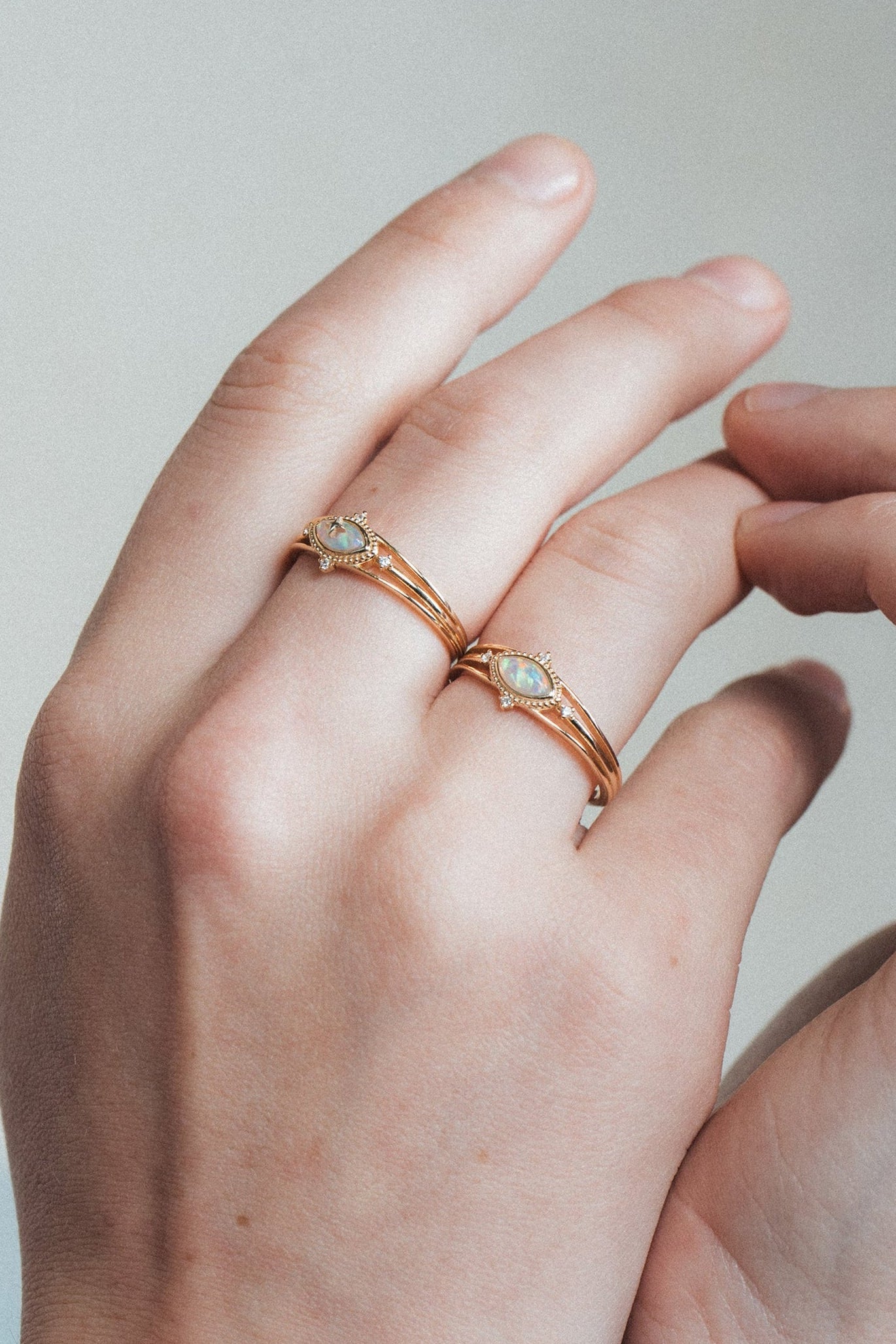 Marquise-cut iridescent opal ring in gold with a triple-band design and north star accents, ethereal celestial jewelry by LIRAE.
