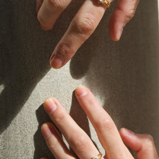 Marquise-cut iridescent opal ring in 14k gold with a triple-band design and north star accents, ethereal celestial jewelry by LIRAE.