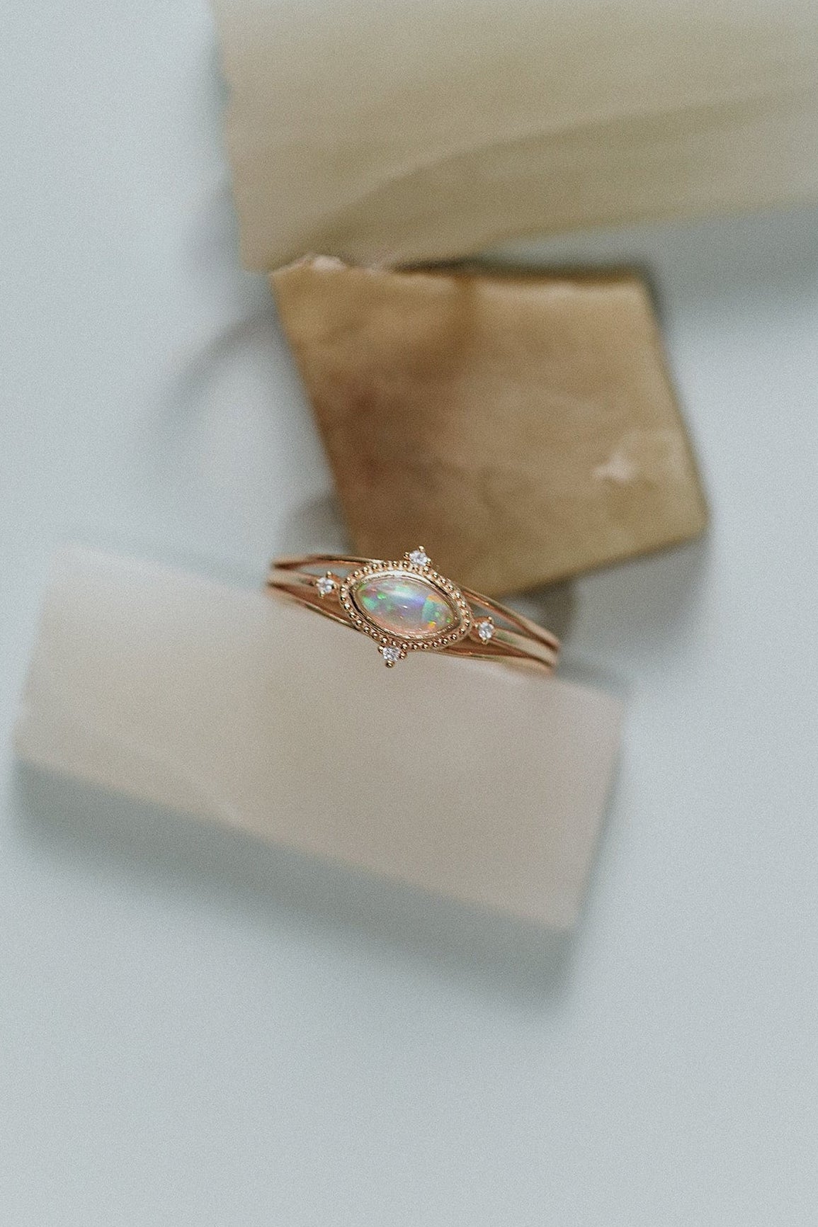 Marquise-cut iridescent opal ring in gold with a triple-band design and north star accents, ethereal celestial jewelry by LIRAE.