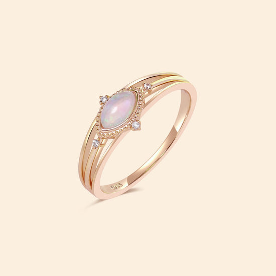 Marquise-cut iridescent opal ring in 14k gold with a triple-band design and north star accents, ethereal celestial jewelry by LIRAE.