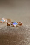 Marquise-cut iridescent opal ring in 14k gold with a triple-band design and north star accents, ethereal celestial jewelry by LIRAE.