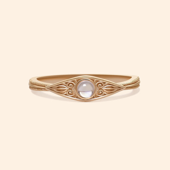 LIRAE moonstone ring featuring golden swirl filigree and an eye-shaped silhouette, ethereal vintage jewelry for women in gold.