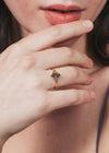 Close-up of a person wearing a gold ring with moss agate.