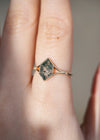 Moss agate ring with green inclusions on delicate gold band.
