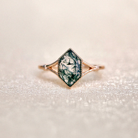 Moss agate ring with green inclusions on delicate gold band.