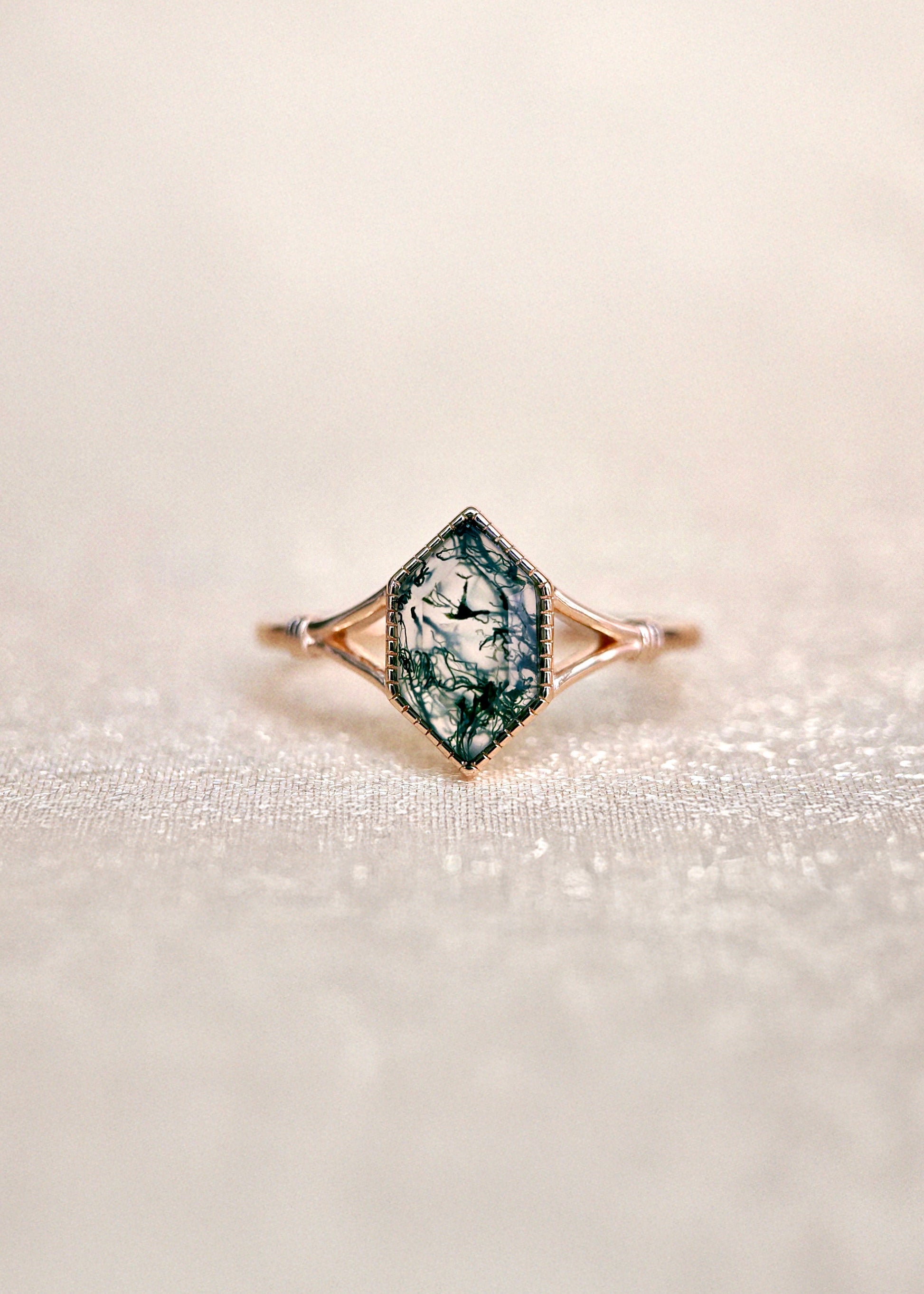 Moss agate ring with green inclusions on delicate gold band.