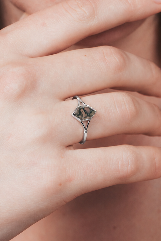 Moss agate ring with green inclusions on delicate silver band.