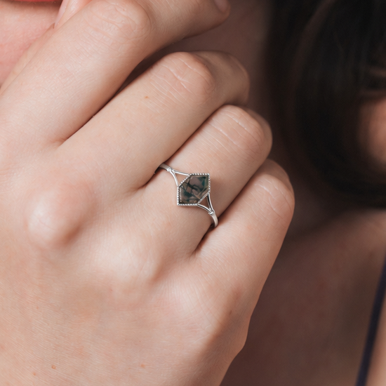 Moss agate ring with green inclusions on delicate silver band.