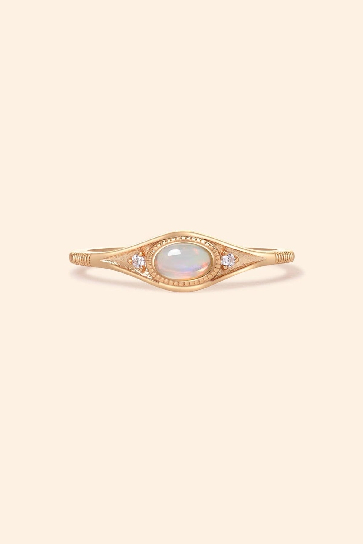 Gold oval opal ring with moissanite accents and vintage-inspired details.
