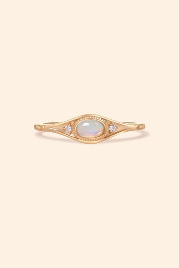 Gold oval opal ring with moissanite accents and vintage-inspired details.