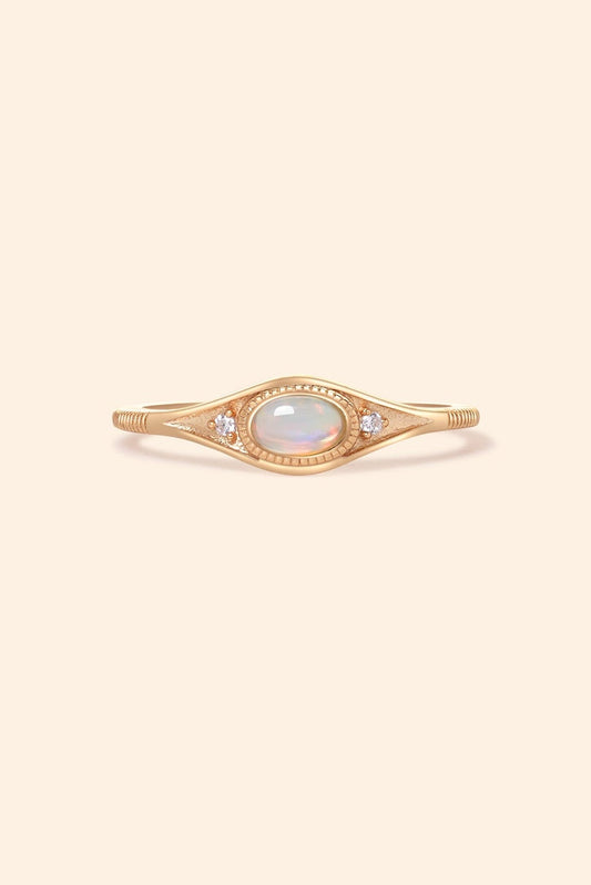 Gold oval opal ring with moissanite accents and vintage-inspired details.