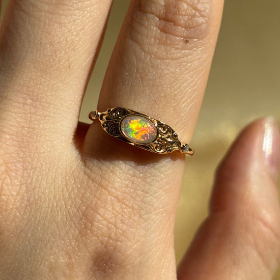 LIRAE vintage-style gold ring with an oval opal center stone and intricate golden swirl filigree, ethereal romantic jewelry for women.