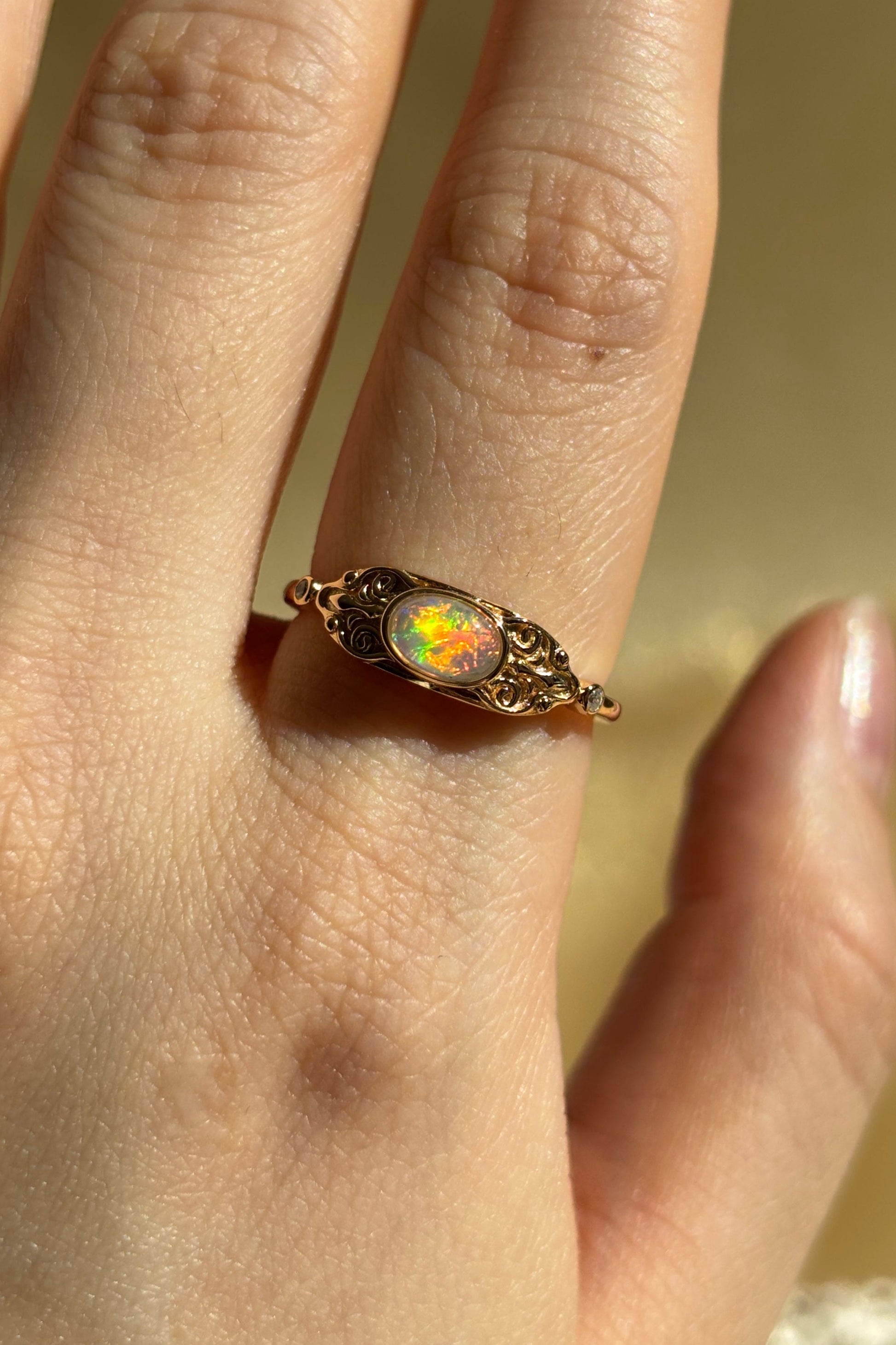 LIRAE vintage-style gold ring with an oval opal center stone and intricate golden swirl filigree, ethereal romantic jewelry for women.