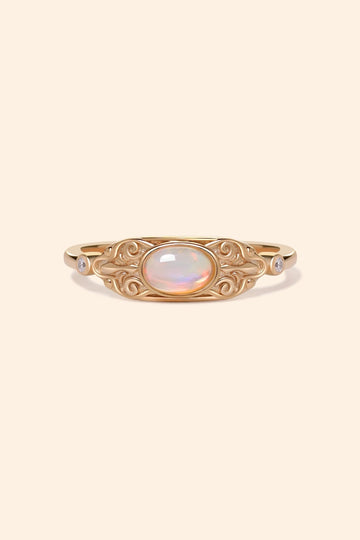 LIRAE vintage-style gold ring with an oval opal center stone and intricate golden swirl filigree, ethereal romantic jewelry for women.