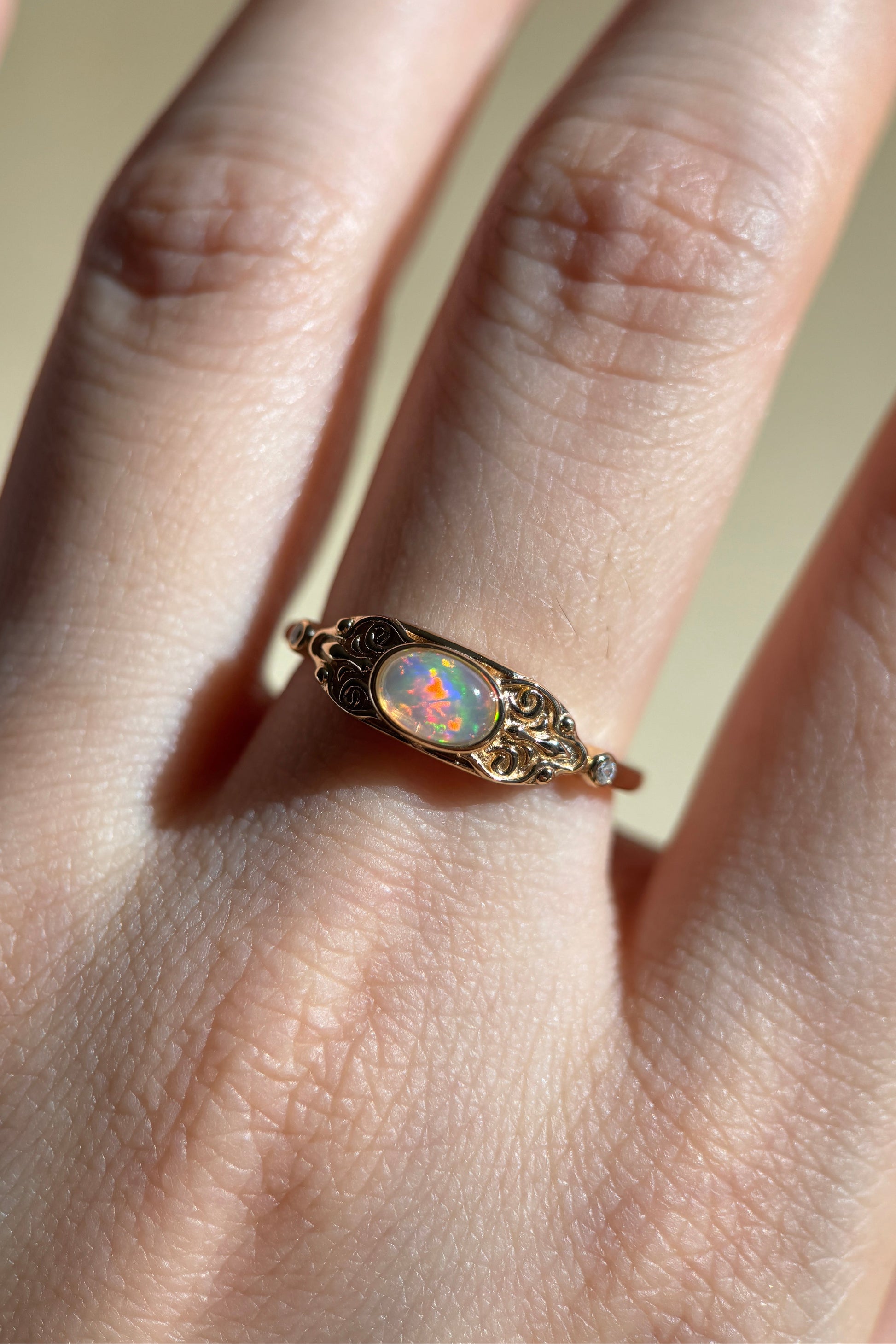 LIRAE vintage-style gold ring with an oval opal center stone and intricate golden swirl filigree, ethereal romantic jewelry for women.