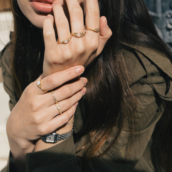 LIRAE vintage-style gold ring with an oval opal center stone and intricate golden swirl filigree, ethereal romantic jewelry for women.