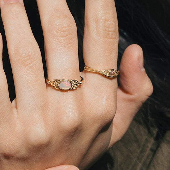 LIRAE vintage-style gold ring with an oval opal center stone and intricate golden swirl filigree, ethereal romantic jewelry for women.