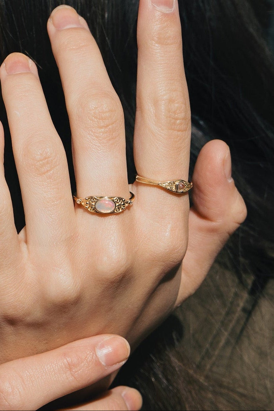 LIRAE vintage-style gold ring with an oval opal center stone and intricate golden swirl filigree, ethereal romantic jewelry for women.