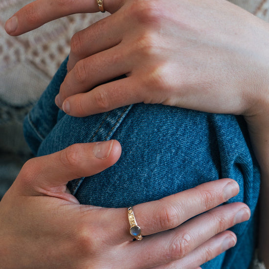 Gold celestial labradorite ring with round center stone and engraved star and moon details