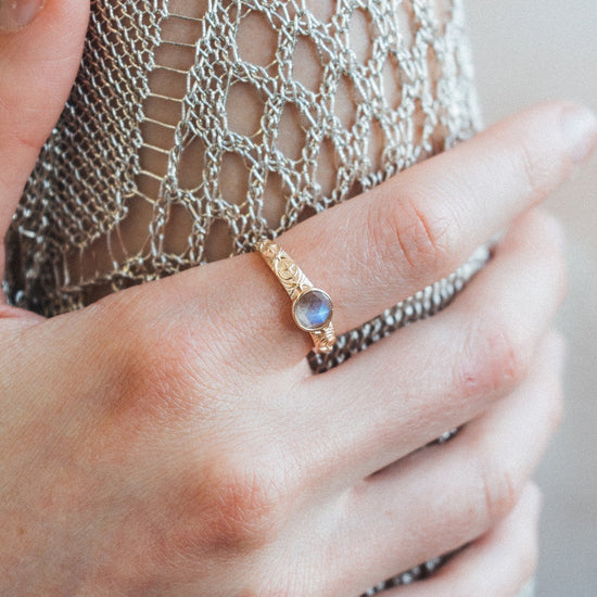 Gold celestial labradorite ring with round center stone and engraved star and moon details