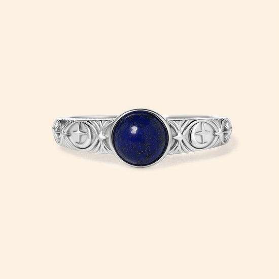 Silver celestial lapis lazuli ring with round blue center stone and engraved moon and star details