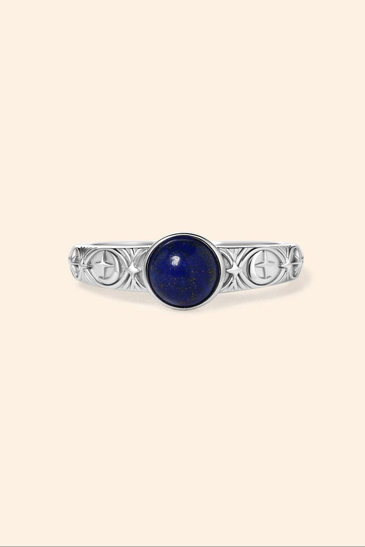 Silver celestial lapis lazuli ring with round blue center stone and engraved moon and star details