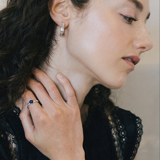 Silver celestial lapis lazuli ring with round blue center stone and engraved moon and star details