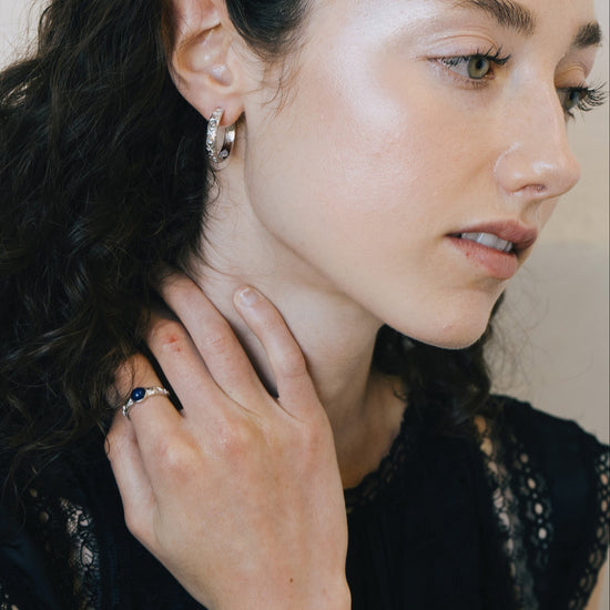 Silver celestial lapis lazuli ring with round blue center stone and engraved moon and star details